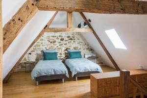 two beds in a attic bedroom with wooden beams at Maison de charme Portobelo dans Carennac avec vue in Carennac
