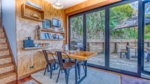 a dining room with a table and chairs and a sliding glass door at Rangi Terrace Views in Karikari Peninsula