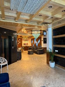 un ampio soggiorno con soffitto con lampadario pendente di White Season Resort - Mountain View With Premium Rooms # Luxury Stay in Manali a Manāli