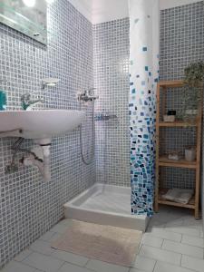 a bathroom with a shower and a sink and a tub at Jenny's Apartments in Milatos
