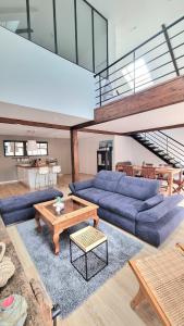 un salon avec des canapés bleus et une table dans l'établissement Avelenn Belle maison de ville avec terrasse, à Concarneau