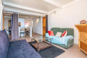een woonkamer met een bank en een tafel bij Jeux de boules 1 - T2 in Le Pradet
