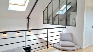 une cage d'escalier avec une chaise et un miroir dans l'établissement Avelenn Belle maison de ville avec terrasse, à Concarneau