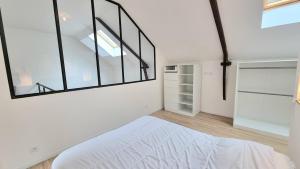 une chambre avec un lit blanc et une grande fenêtre dans l'établissement Avelenn Belle maison de ville avec terrasse, à Concarneau 45 autres photos