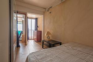 een slaapkamer met een bed en een tafel met een lamp bij Jeux de boules 1 - T2 in Le Pradet