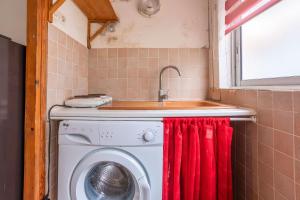een badkamer met een wasmachine en een wastafel bij Jeux de boules 1 - T2 in Le Pradet