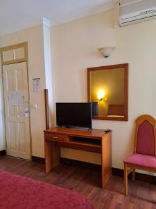 a room with a desk and a mirror and a red chair at Residencial Dom Duarte in Viseu
