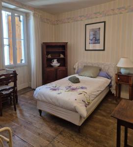 a bedroom with a bed with flowers on it at Chez Mamie Gramat centre in Gramat