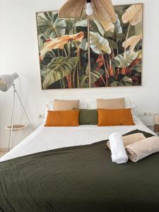 a bedroom with a large bed with a painting on the wall at San Mateo Loft in Tarifa