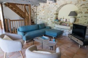 a living room with a blue couch and a tv at Maison de charme Portobelo dans Carennac avec vue in Carennac