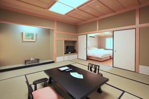 a room with a table and chairs and a bed at Kasuga Hotel in Nara