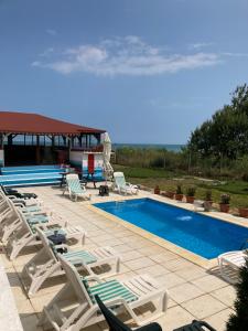 a group of lounge chairs and a swimming pool at Piovra in Vama Veche