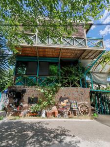 a house with a bunch of items in front of it at Qilimcha's Guesthouse & Art-Stay in Telavi