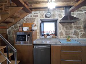 a kitchen with a stove and a sink in a room at A Florentina in Rubiacós