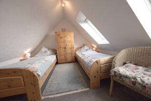 a attic room with two beds and a chair at Ferienwohnung Boje 15 in Schillig