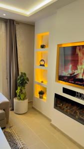 un salon avec une télévision et une cheminée dans l'établissement N8 appartement, 3 Chambres Haut de Gamme, a Deux Pas de l Ocean et du Mall, à Rabat