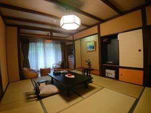 a living room with a table and a room with a couch at Kasuga Hotel in Nara