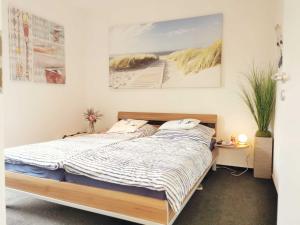 a bedroom with a bed and a painting on the wall at Ferienwohnung Granata 52 0S in Schillig