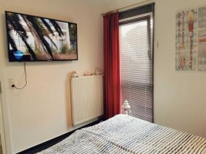 a bedroom with a bed and a television on the wall at Ferienwohnung Granata 52 0S in Schillig +6 photos
