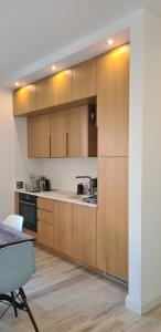a kitchen with wooden cabinets and a table and chairs at CityHeart Apartment in Nikšić