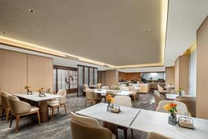 une salle à manger avec tables et chaises dans l'établissement Atour Hotel Zhengzhou Convention and Exhibition Center Shangdu Road, à Zhengzhou