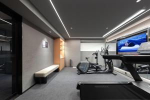 Cette chambre comprend une salle de sport avec un tapis de course et une télévision. dans l'établissement Atour Hotel Zhengzhou Convention and Exhibition Center Shangdu Road, à Zhengzhou