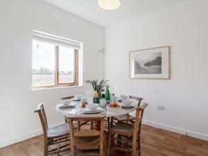 Un comedor blanco con una mesa y sillas. en 2 Bed in Burnham Market 40757, en Great Bircham 4 fotos más