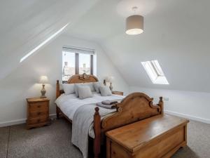 Un dormitorio con una cama grande con cabecero de madera. en 2 Bed in Burnham Market 40757, en Great Bircham