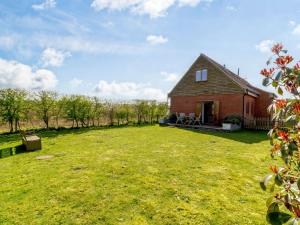una casa de ladrillo rojo con un gran patio de césped en 2 Bed in Burnham Market 40757, en Great Bircham