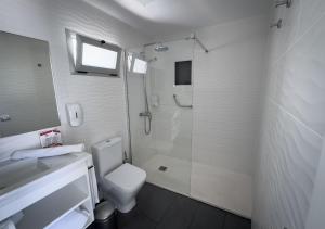 a white bathroom with a shower and a toilet at Holiday Club Puerto Calma in Puerto Rico de Gran Canaria