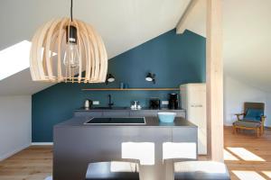 a kitchen with a sink and a blue wall at Elsas Enkel - Ferienwohnung Gesa in Waabs