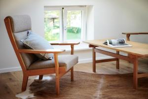 a chair and a desk with a table and a window at Elsas Enkel - Ferienwohnung Gesa in Waabs