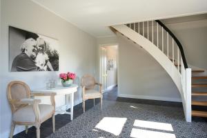 a dining room with a table and chairs and a staircase at Elsas Enkel - Ferienwohnung Gesa in Waabs