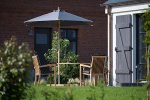 a table and two chairs under an umbrella at Elsas Enkel - Ferienwohnung Meta in Waabs