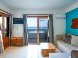 a living room with a couch and a view of the ocean at Theodora Suite by Pegasus in Kardamaina
