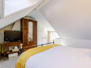 a white bedroom with a bed and a tv at 2 Bed in Robin Hoods Bay 87059 in Robin Hood's Bay