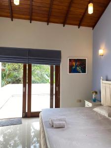 a bedroom with a bed and a large window at La Vie Pearl- Private Villa- Kadawatha in Kadawata