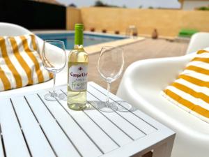 a bottle of wine sitting on a table with two wine glasses at Casa del Sol with private pool in Mazarrón