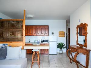a kitchen with a white refrigerator and a table at Theodora Suite by Pegasus in Kardamaina