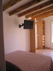 - une chambre avec un lit et une télévision murale dans l'établissement E Stelle di A Bella Vista, à Bonifacio