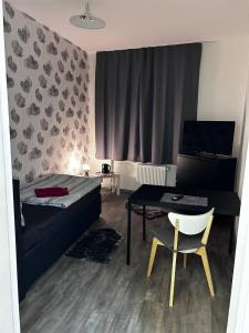 Un dormitorio con una cama, un escritorio y una mesa. en FeWo Vermietung Plauen, en Plauen