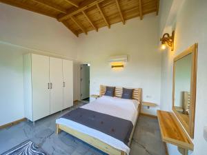 una camera da letto con un letto grande e uno specchio di Villaderyadeniz a Kızılyaka Altre 20 foto