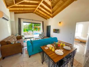 un soggiorno con un divano blu e un tavolo di Villaderyadeniz a Kızılyaka