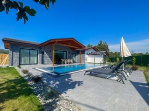 un patio con piscina e una casa di Villaderyadeniz a Kızılyaka