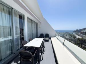 a balcony with tables and chairs and the ocean at Holiday Club Puerto Calma in Puerto Rico de Gran Canaria