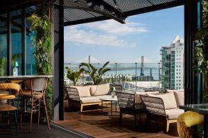 um pátio com cadeiras e mesas e vista para o oceano em Tivoli Oriente Lisboa Hotel em Lisboa