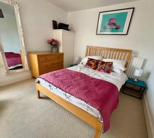 a bedroom with a bed and a large mirror at Stylish Victorian Cottage, 2mins from Whitstable Harbour & Shops in Whitstable