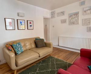 a living room with a brown couch in a room at Stylish Victorian Cottage, 2mins from Whitstable Harbour & Shops in Whitstable