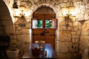 a room with a table and a window in a stone wall at Trulli al Chiaro di Luna in Putignano