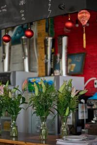 three vases with flowers in them on a table at Vietnam Surf Camp in Ấp Mỹ Hải